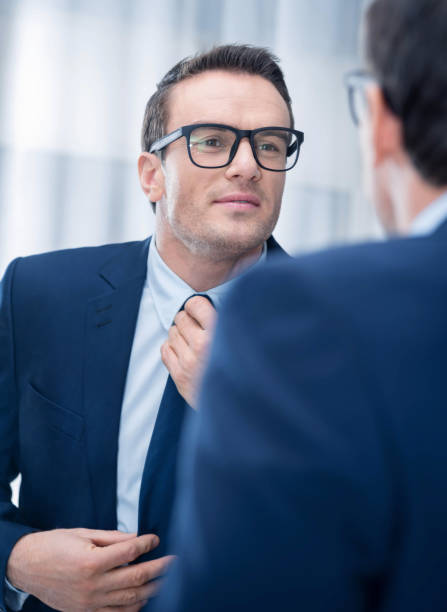 istock Pensive pleasant man looking at the mirror 890847460