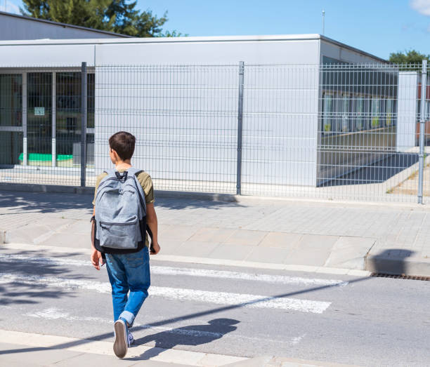 istock Teenage school boy with a backpack on his back walking to school 890847530