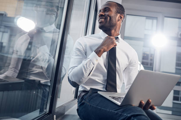 istock Cheerful manager is adjusting his necktie 890849696