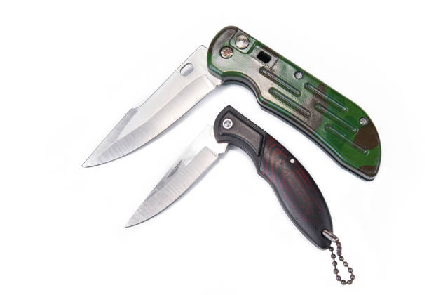one old folding knife lies behind a brown pocket on a backpack on a summer street