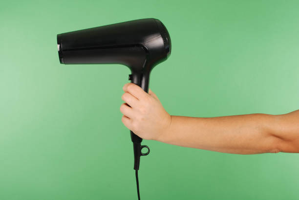 istock Hand holding hair dryer 890867976