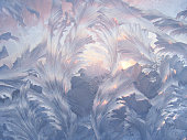 Beautiful ice pattern and sunlight on winter window glass