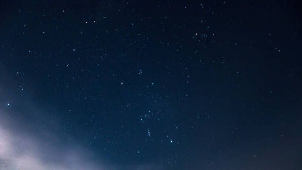 istock Constellation of the orion on a beautiful, night, starry sky with clouds. 890882596