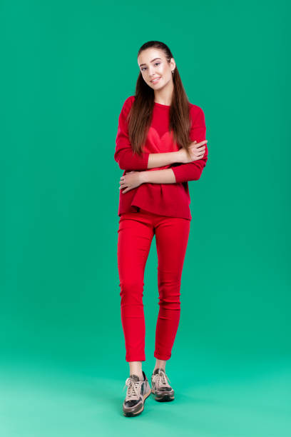 istock woman in red sweater on green background 890884138