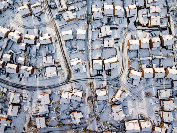 Aerial view of snowed in traditional housing suburbs in England. Snow, ice and adverse weather conditions bring things to a stand still. row house photos stock pictures, royalty-free photos & images