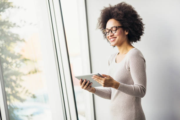 istock Young businesswoman working in modern office on a digital tablet 890886490