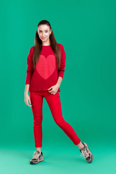 istock woman in red sweater on green background 890886570