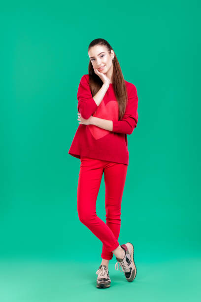 istock woman in red sweater on green background 890886822