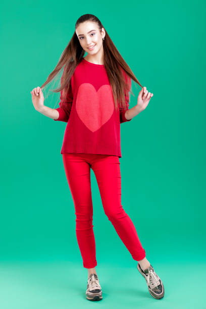 istock woman in red sweater on green background 890887148