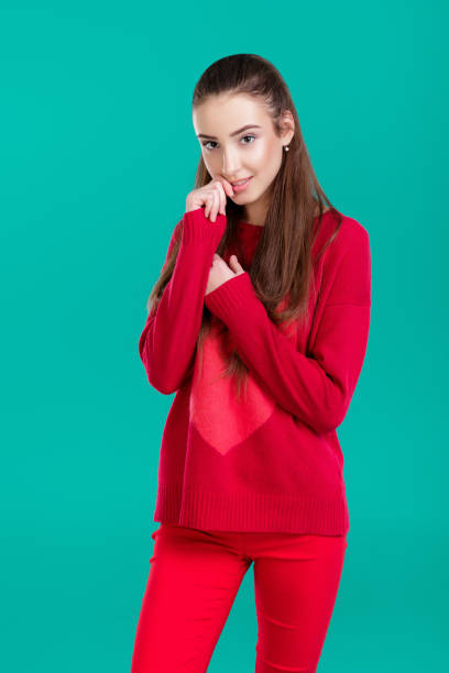 istock woman in red sweater on green background 890913666