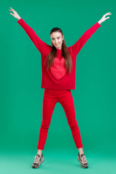 istock woman in red sweater on green background 890913982