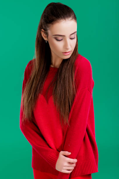 istock woman in red sweater on green background 890914130