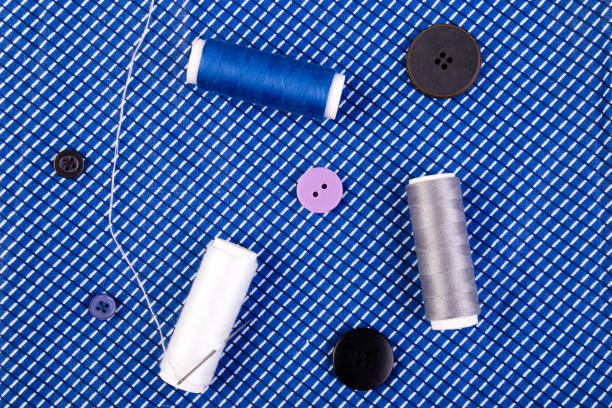 istock Items for sewing clothes. Sewing buttons, spools of thread and cloth. Top view. 890924594
