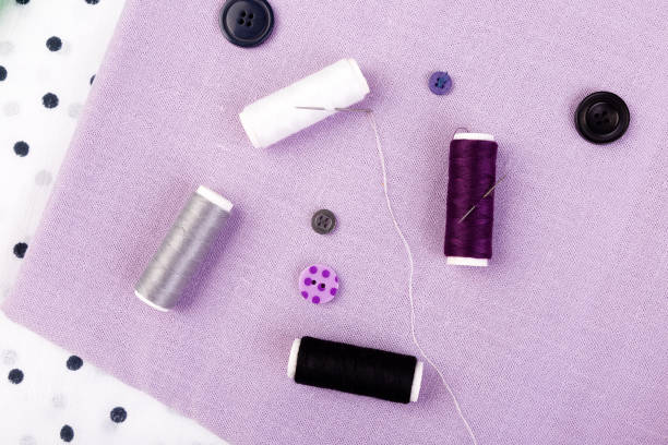 istock Items for sewing clothes. Sewing buttons, spools of thread and cloth. Top view. 890924602