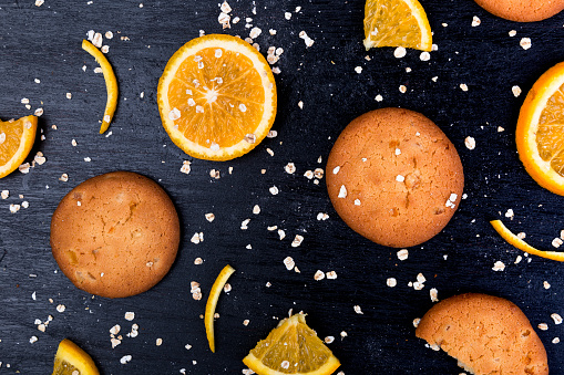 Oatmeal cookies and orange citrus fruit background. Flat lay.