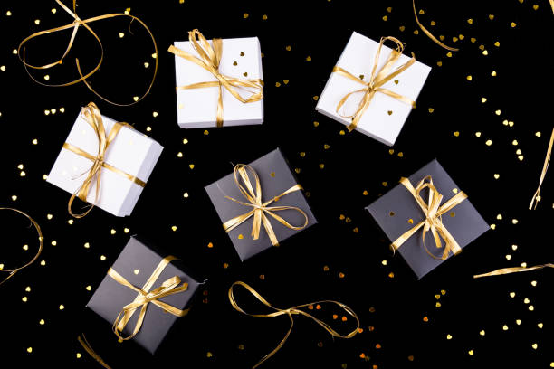 istock Black and white gift boxes with gold ribbon on shine background. Flat lay. 890931958