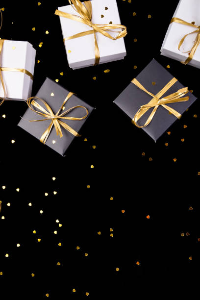 istock Black and white gift boxes with gold ribbon on shine background. Flat lay. Copy space. 890931962