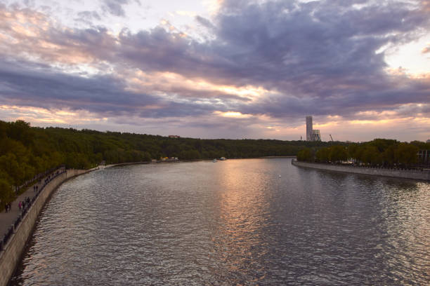 Cityscape at sunset with large river at foreground and sunset clouds at background
