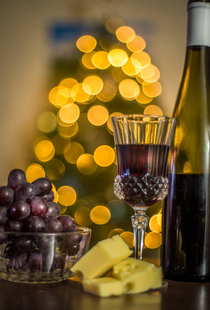 Glass half full of red wine and cheese and grapes