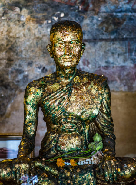 statua del monaco buddista meditata con offerte di foglie d'oro - wat pho foto e immagini stock