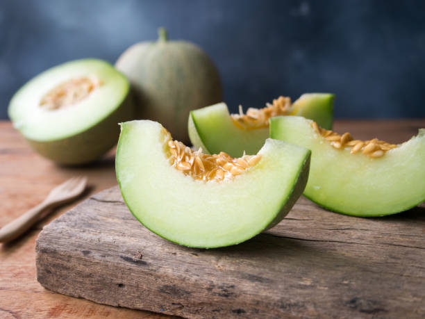 Fresh japanese green melon fruit. Fresh japanese green melon fruit sliced on wooden cutting board. honeydew melon stock pictures, royalty-free photos & images