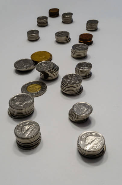 vertikal ram av korta stackar av mynt som leder bort i fjärran på vit bakgrund - endollarsmynt kanadensiskt mynt bildbanksfoton och bilder