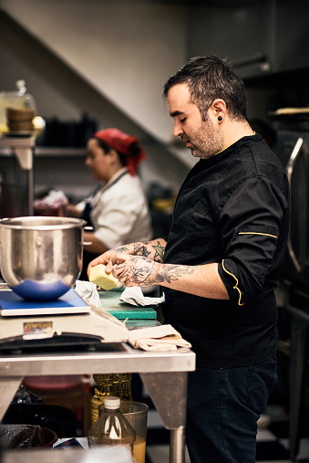 Shot of a focused chef preparing a dish in the kitchen of a restaurant