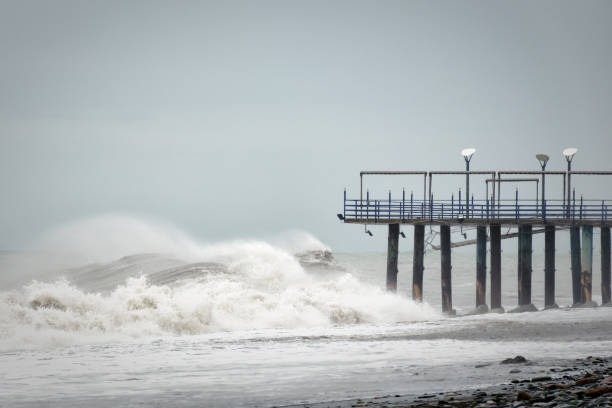 Storm waves on the sea are broken about the pier.