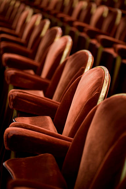 Rows of red velvet theatre seats stock photo