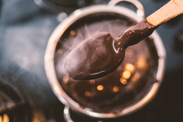 pudin de chocolate en cuchara de madera en la cocina - chocolate pot de creme fotografías e imágenes de stock