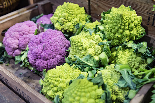 Purple cauliflower and Broccoflower in wooden crate at Market read for sale