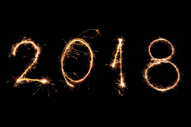 istock 2018 written with Sparkle firework on black background, happy new year 2018 concept 891002850