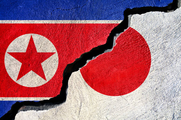 istock Concept North Korea and Japan flag on cracked background 891003424