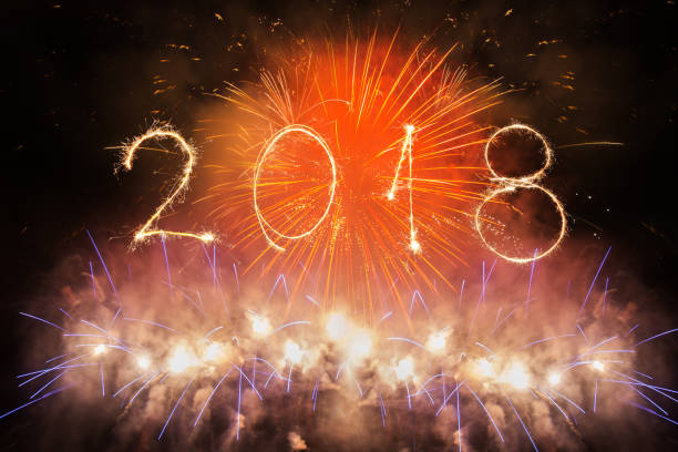 istock 2018 written with Sparkle firework on black background, happy new year 2018 concept 891004048