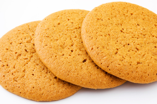 Closeup shot of three ginger cookies on white.