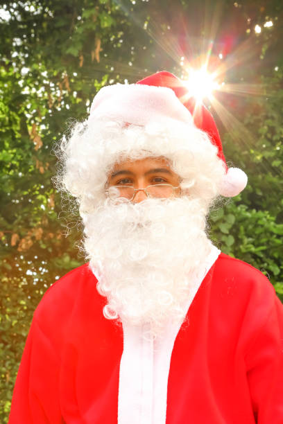 Santa portrait with sun flare behind. This is a Latin American Santa, with darker skin and no blue eyes.