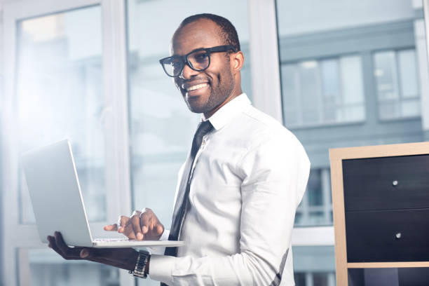 istock Cheerful professional businessman is typing on notebook 891020890