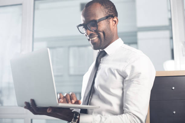 istock Qualified stylish man is laboring on notebook with smile 891021062
