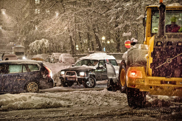 Stockholm, Sweden - November 09, 2016: Terrible snow storm in central Stockholm, Sweden. Traffic chaos on Sveavagen. Tractor trying to clear roads.