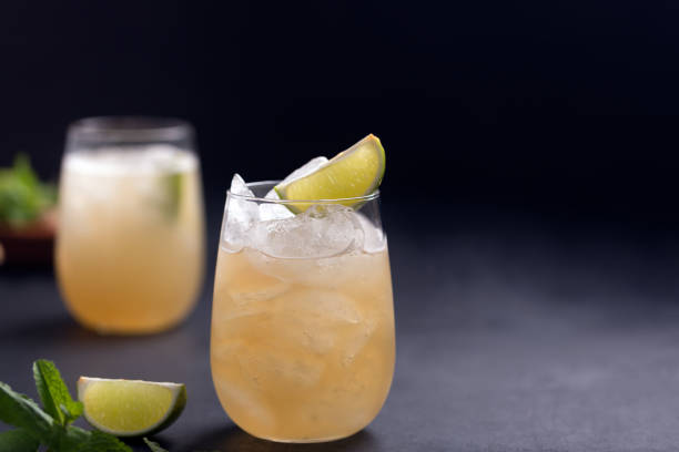 Fresh cocktail prepared with ginger beer, lime and ice. Black background stock photo