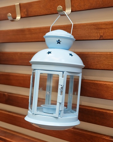 Decorative Light Blue Vintage Lantern Hanging on A Wooden Wall, Used to Illuminate Surrounding Space for Decorations and Atmosphere.