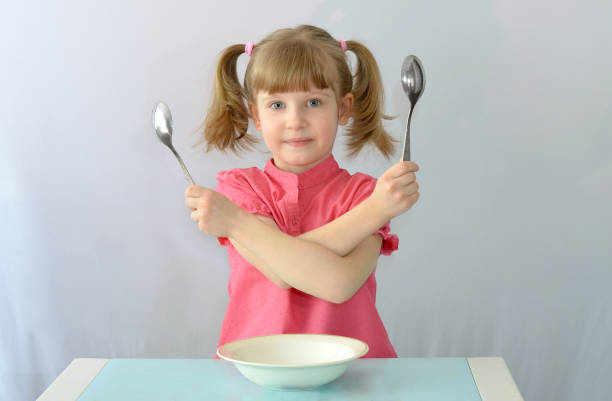 istock Child, kid,left-handed do not know which hand to hold a spoon 891052452