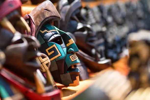 Colorful wood carving traditional Mayan mask souvenirs made by local artisans sold to tourists