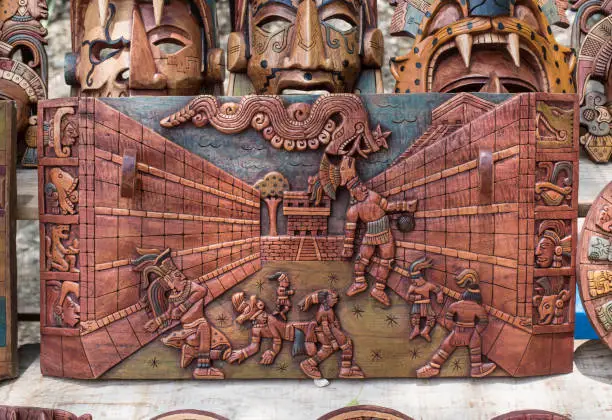 Wood carving souvenir depicting the traditional The Mayan Ball Game (Mesoamerican ball game) and wood masks.