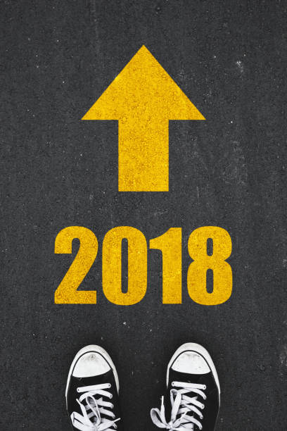 istock New year 2018 text on asphalt with standing people shoes 891061524