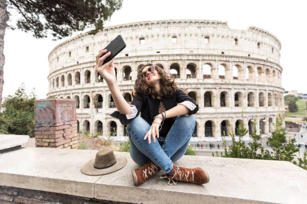 istock Young woman taking selfie in front of Coliseum 891103290