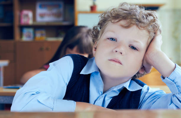 istock Boy listening during a lesson at an elementary school. School boy looking at the camera in classrum. 891103778