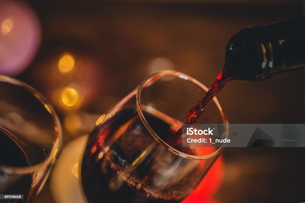 Red Wine Pouring into glass Night Stock Photo