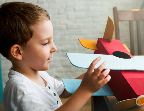 istock Little boy happily playing with his toy plane 891126320