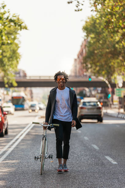 istock Handsome afro man walking with his bike. 891126446